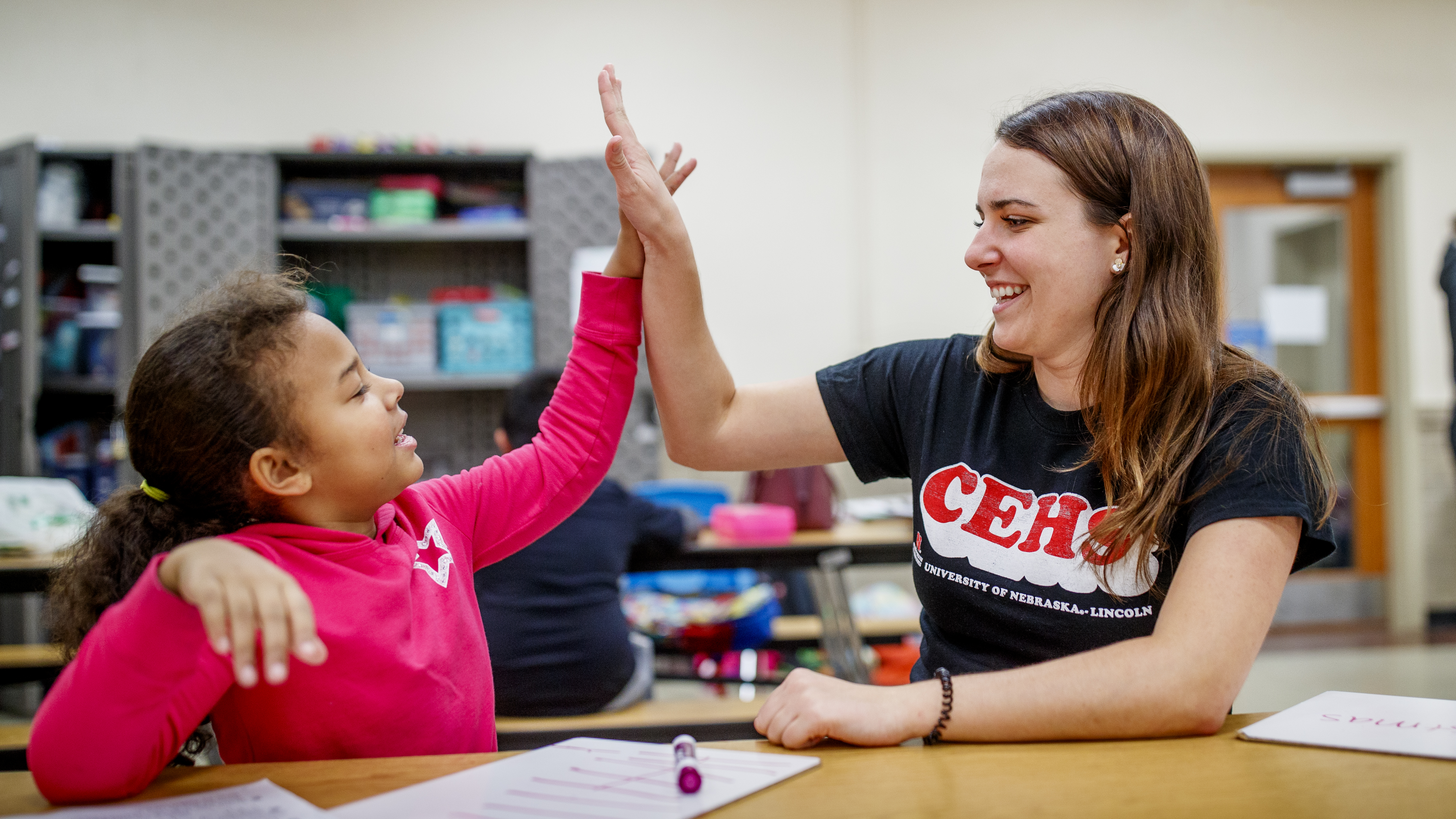 CEHS student high fives elementary aged child during America Reads program