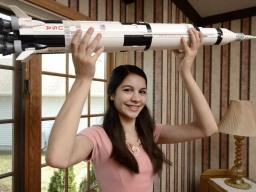Amanda Gutierrez holds a model of a NASA Saturn V rocket, which was used to send astronauts to the moon. FRANCIS GARDLER, Journal Star 