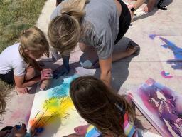 Students from the Alliance Recreation Center create spray chalk animals as part of the Stay Wild community arts project, led by Associate Professor of Art Sandra Williams. Courtesy photo.