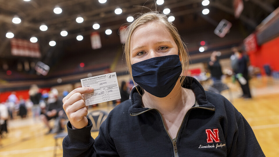 Nebraska's Whitney Steckel displays her vaccine card after getting her first inoculation during an on-campus clinic on April 20. [Craig Chandler | University Communication]