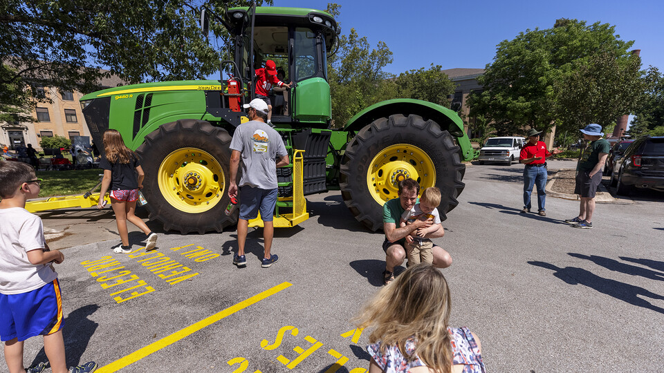 Children examine a John Deere tractor during East Campus Discovery Days on June 12. Craig Chandler | University Communication