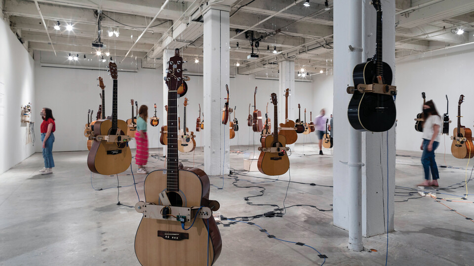 Guitars hang in the air as patrons examine the "Soundtracks for the Present Future" exhibition in Omaha's Bemis Center for Contemporary Arts. Courtesy photo.