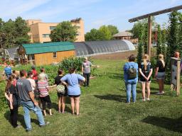 Nebraska high school students and their families listen to Stacy Adams, The Biggest Grower program coordinator, speak about speciality crop production near the East Campus Hops Planting Garden on June 30.