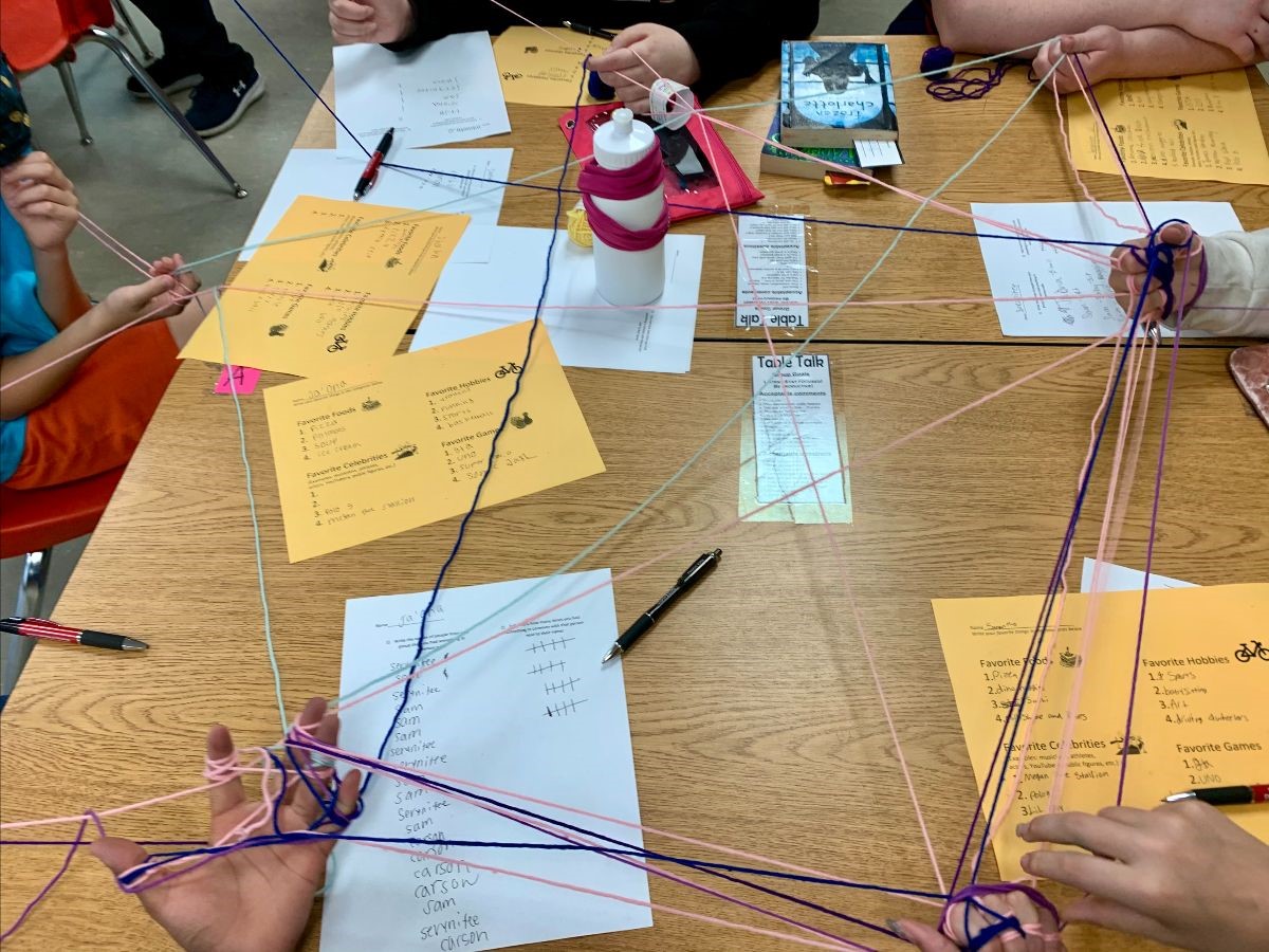 Youth discover connections to each other by creating a network model of shared interests out of yarn.