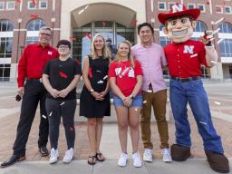 Chancellor Ronnie Green and Herbie stand on either side of the Voluntary COVID-19 Vaccine Registry grand prize winners (from left) Alex Chytil, Jenna Huttenmaier, Sidney Vincent and Dan Nguyen. Not pictured are Griselda Aragon and Samuel Flint. [Craig Cha