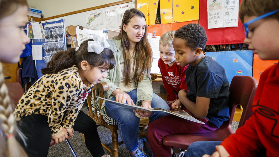 Megan Groth, then a sophomore, reads to first-grade students at Saratoga Elementary school as part of the America Reads/America Counts project in this photo from 2019. The university has participated in the America Reads/America Counts program for more th