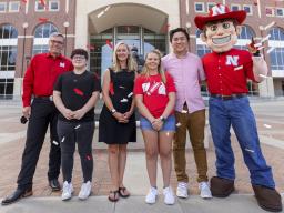 Chancellor Ronnie Green and Herbie stand on either side of the Voluntary COVID-19 Vaccine Registry grand prize winners (from left) Alex Chytil, Jenna Huttenmaier, Sidney Vincent and Dan Nguyen. Not pictured are Griselda Aragon and Samuel Flint.