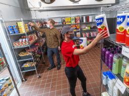 Morgan Berg (right), a senior in psychology from West Fargo, North Dakota, and Tim Anderson, a third-year law student from Huntington Beach, California, stock the shelves in the new East Campus Food Pantry. The pantry is in Filley Hall in the old Dairy St