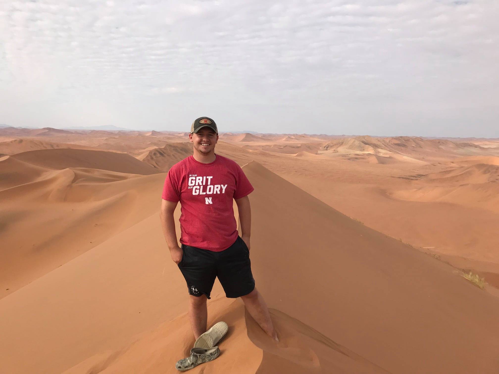 A male Husker stands on one of the tallest sand dunes in the world through a study abroad program in Namibia in 2019. Credit: Education Abroad Office