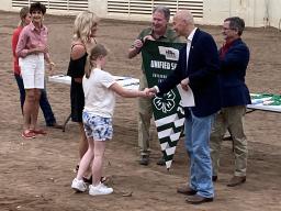 Governor Pete Ricketts shakes hands with a member of the Unified Showing 4-H club.