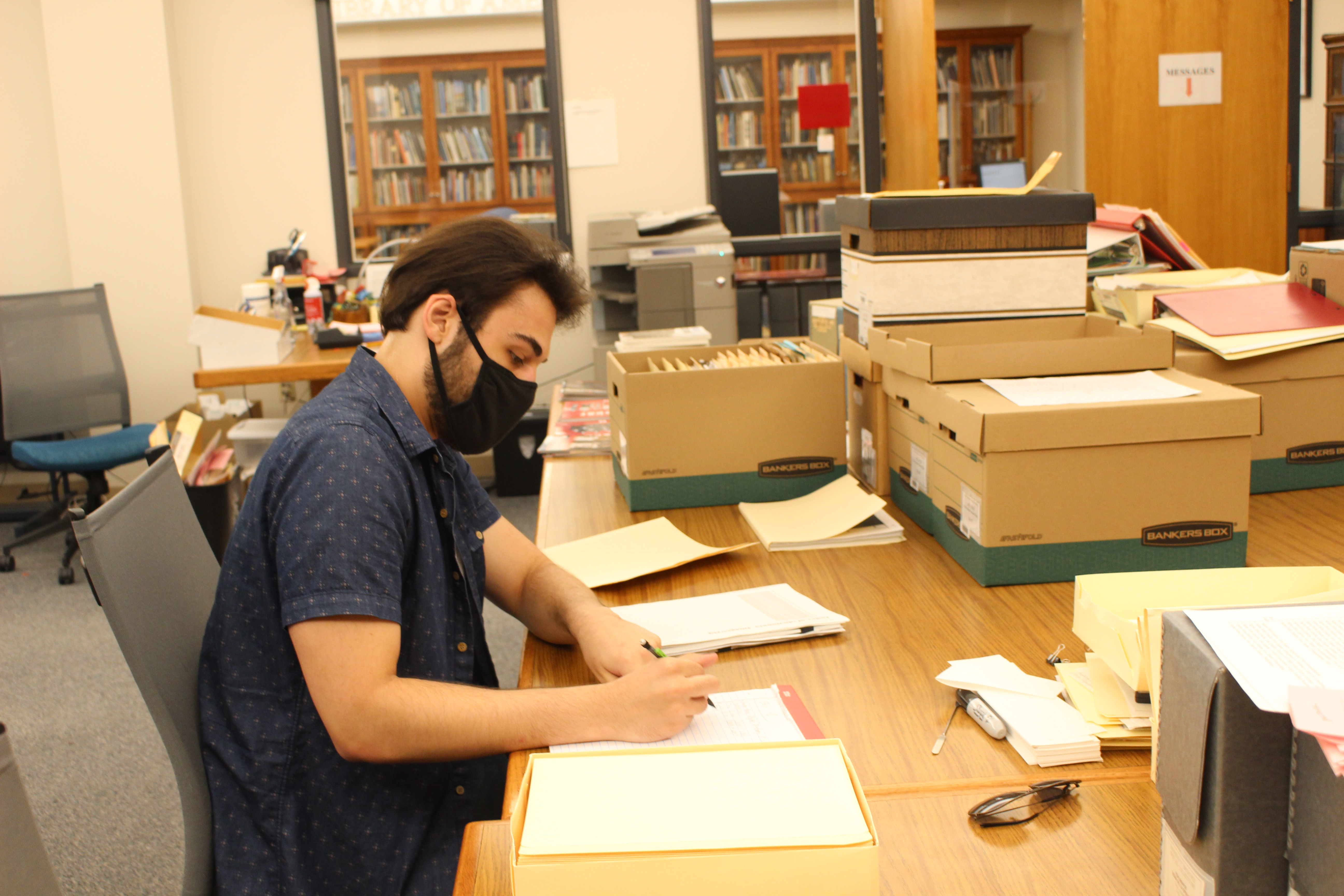 Jake Borgmann, senior, works in the Archives & Special Collections processing the Mark Awakuni-Swetland Papers.