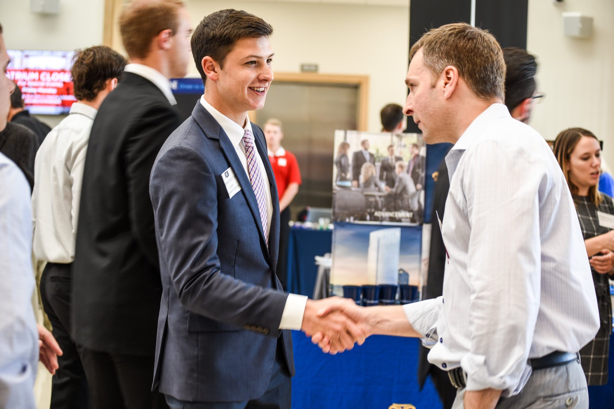 A student shakes an employers hand at the career fair.