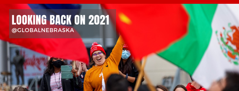A student smiles and waves to international students carrying their national flags during the 2021 Homecoming Parade. © Mia Azizah, Office of Global Strategies
