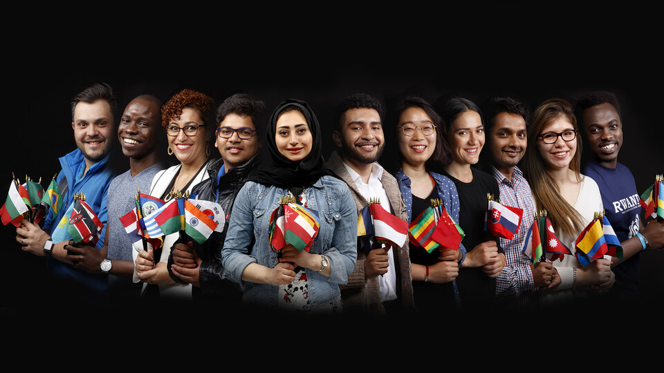 International students and faculty members stand with their national flag. The Forward Together global strategy will help Nebraska expand its global engagement and education activities.