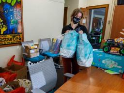A Holidays for Little Huskers organizer carries gifts in to the Women's Center.