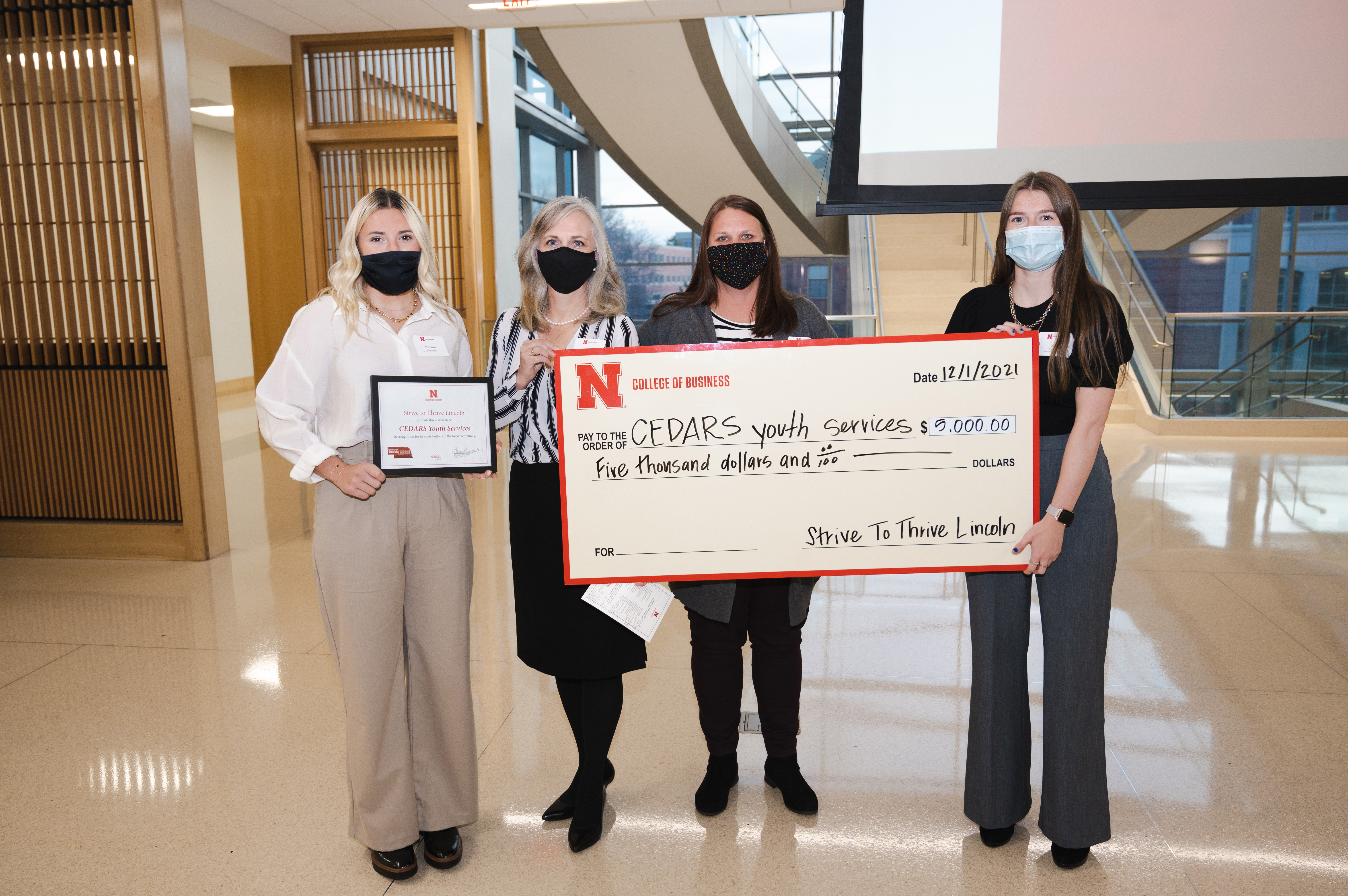 CEDARS check presentation by Paxton Brittingham (far left) and Zoe Matheson (far right) to Cindy Ryman-Yost, Grant Development Director, and Christina Lloyd, Program Director.