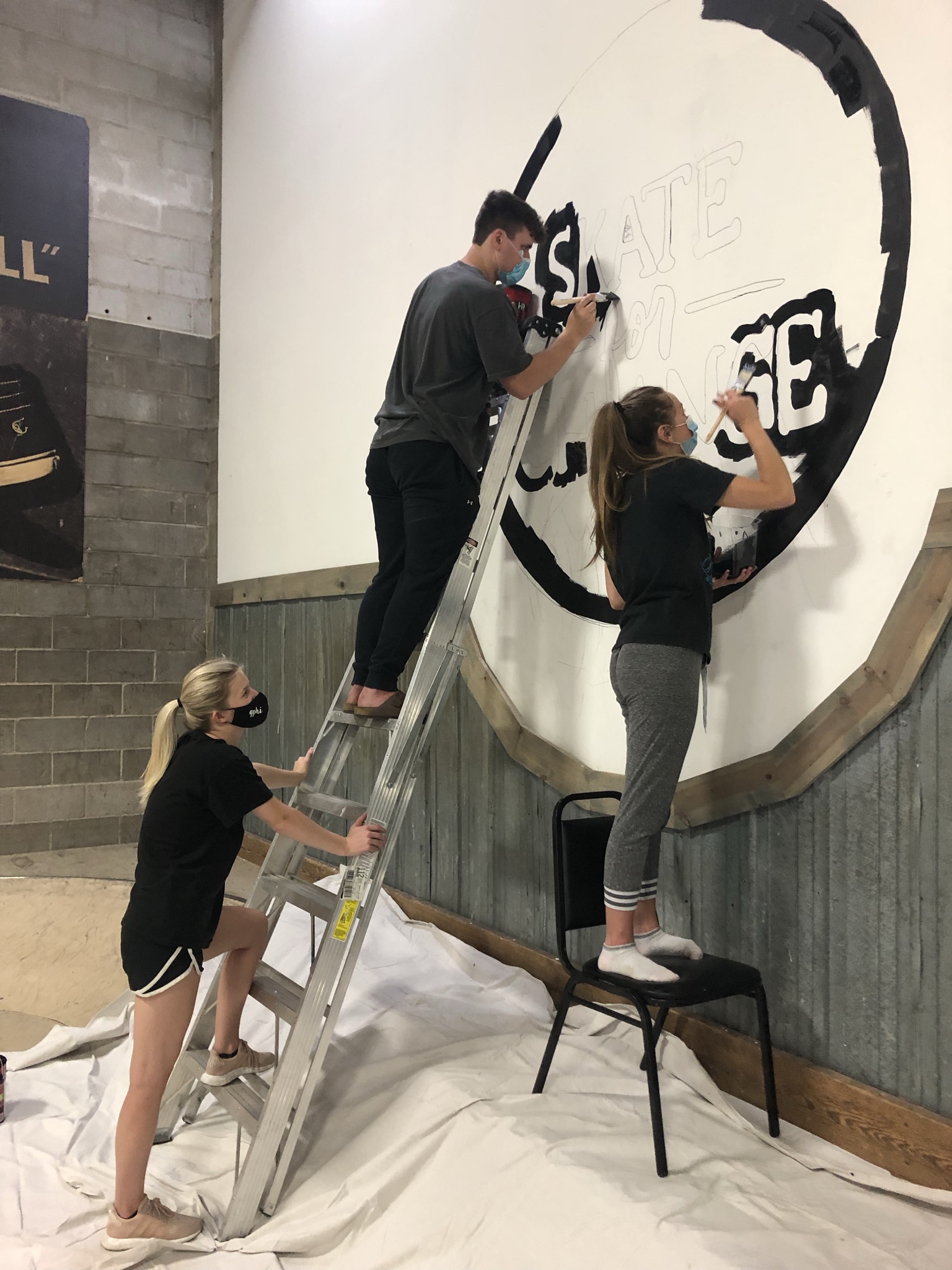 Members of MNGT 411 spend their Friday afternoon painting logos on the walls of The BAY's indoor skatepark.