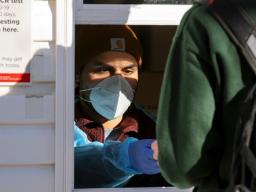 A student delivers a vial of saliva at the Nebraska Union COVID-19 test location on Jan. 18. // University Communications