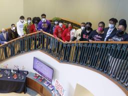 Students in the university's Divine Nine Greek organizations pose on the Gaughan Center steps wearing their letters.