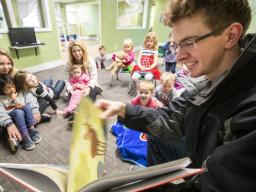 Thomas Kerr, a senior accounting major from Hastings, reads to children at the Foundations Progressive Learning Center during the Husker Reading Challenge