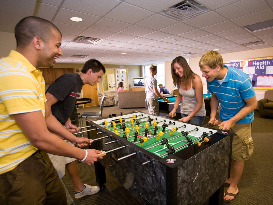 University Housing residents play foosball in a game room while getting to know one another.