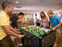 University Housing residents play foosball in a game room while getting to know one another.