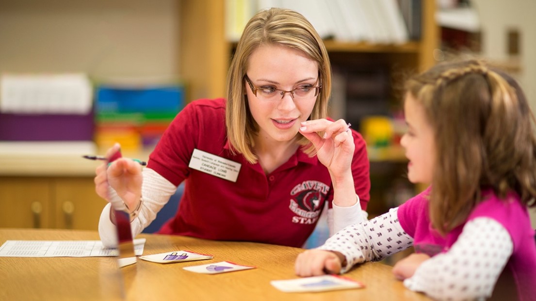 A Communication Sciences and Disorders student working with a child