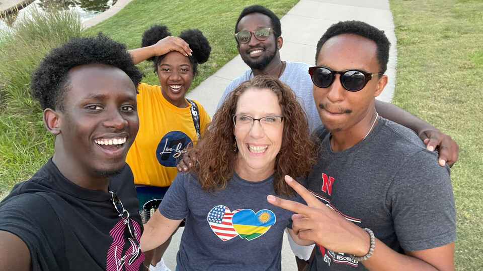 Mikki Sandin, international business and inclusion coordinator, stands with students from the Rwandan Student Association during a summer event. Sandin was honored during Women’s History Month for her community impact.