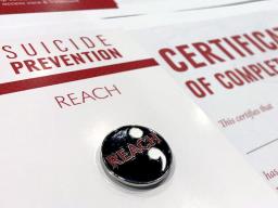 The REACH suicide prevention lapel pin and certificate of completion given to participants who attend the in-person 90-minute training.