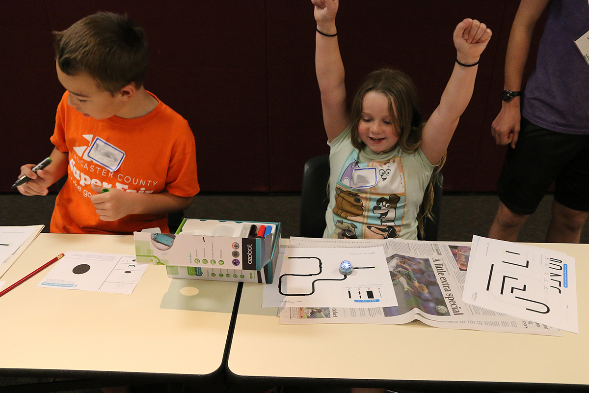 Two youth working with ozobots