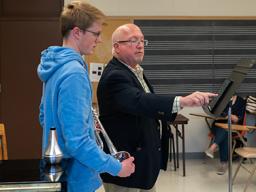 Left: Abby Miller (right) visits with students and faculty in the Johnny Carson School of Theatre and Film. Right: Tim Andersen conducts a masterclass with trumpet students in the Glenn Korff School of Music. Photos by Eddy Aldana.