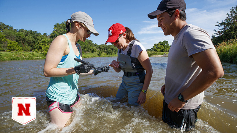 Jessica Corman (center), Matthew Chen (right) and Kayla Vondracek collect samples from the Niobrara River during a 2019 research expedition. 