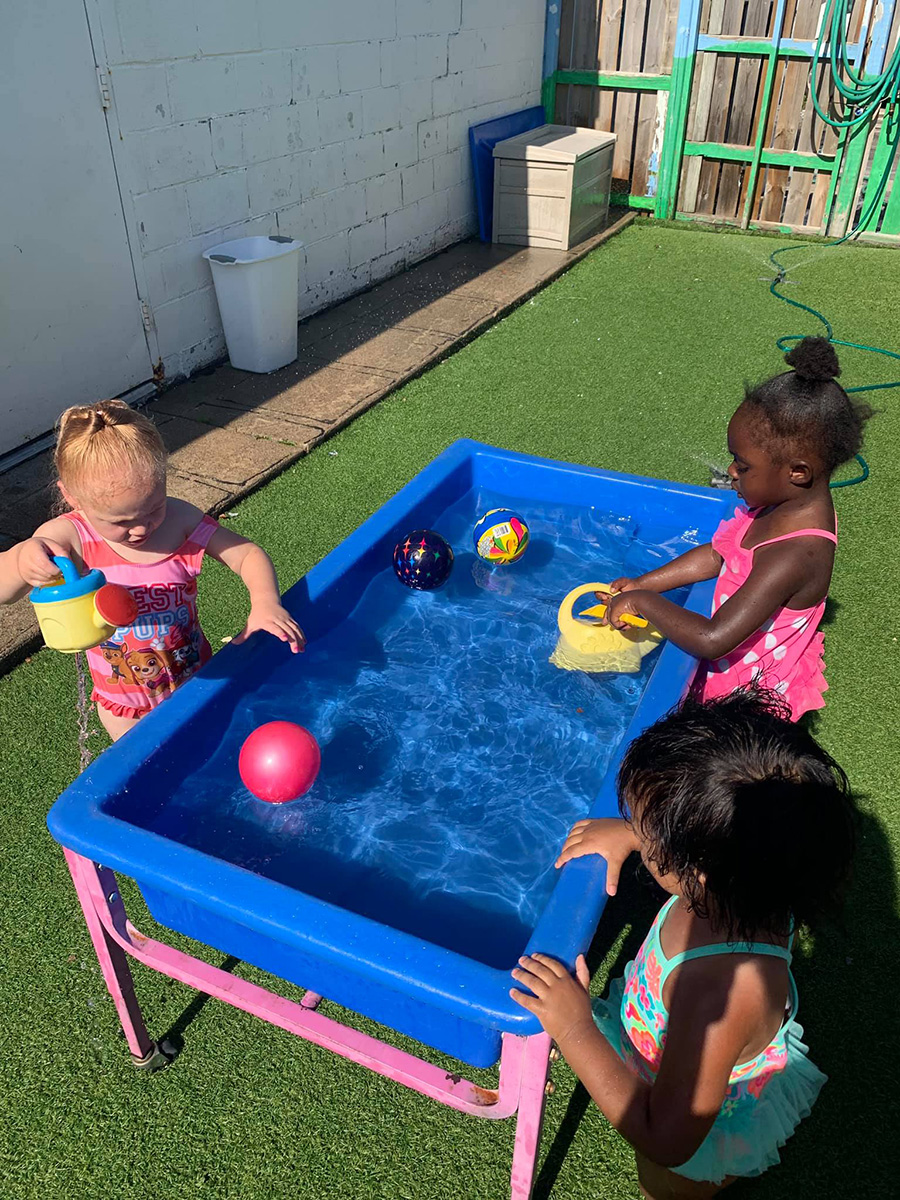 Children playing, dumping and pouring in the water. (Photo courtesy of Kids Imagination Station)