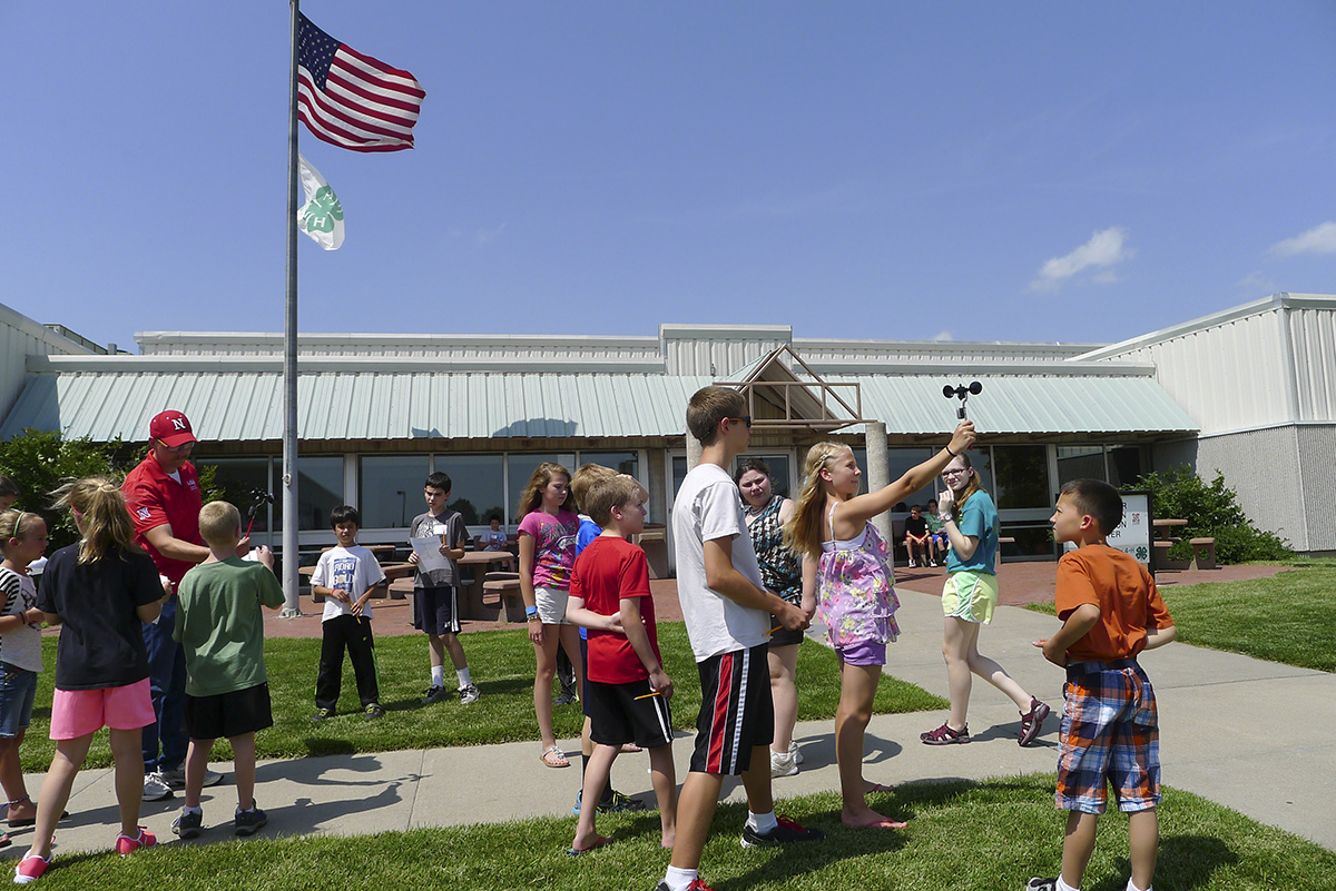 youth holding wind speed devices