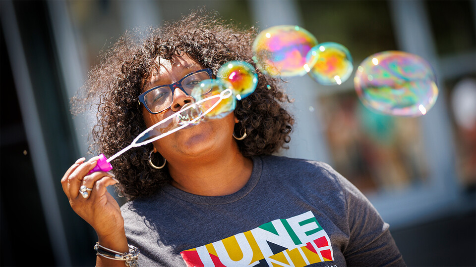 Charlie Foster, assistant vice chancellor for inclusive student excellence, blows a series of bubbles across the Nebraska Union Plaza during the university’s inaugural celebration of Juneteenth. [Craig Chandler | University Communication and Marketing]