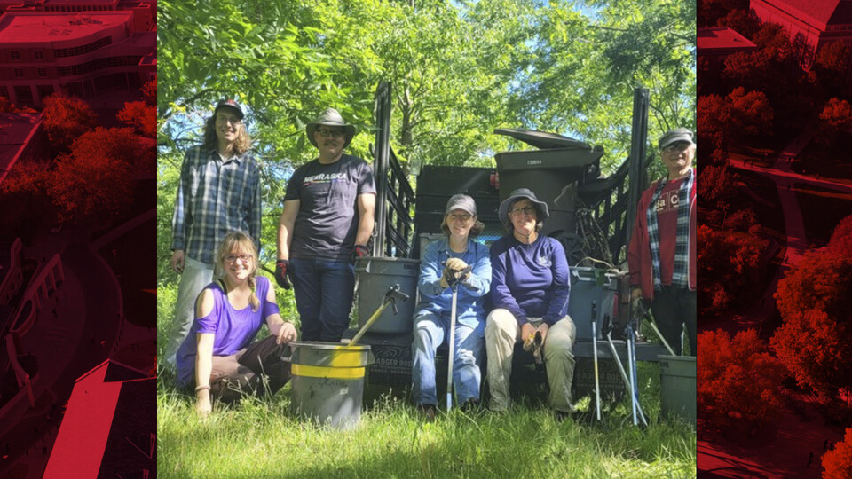 Pesticide Safety Education Program's Greg Puckett (first from left) and Jennifer Weisbrod (crouched, second from left), along with other volunteers, stand in front of the truck that was used to assist the removal of trash in the creek. 