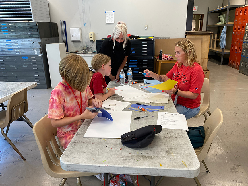 Jen Landis helps students in her “Art of the Poster” class for Future Husker University refine their poster ideas.