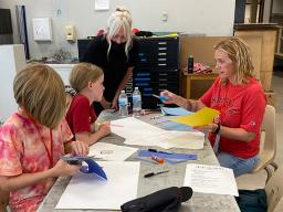 Jen Landis helps students in her “Art of the Poster” class for Future Husker University refine their poster ideas.