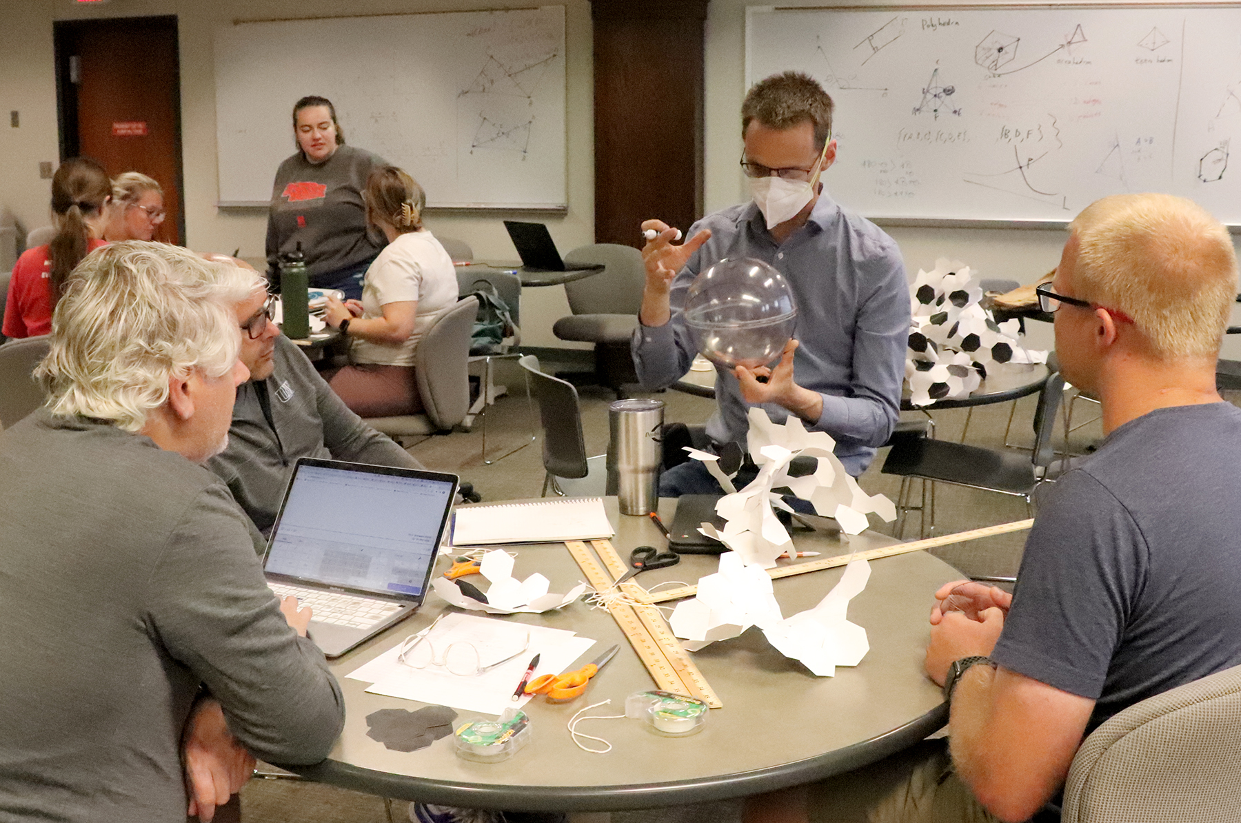 Dr. Adam Larios (second from right) demonstrates on a Lenart sphere during Math 812T: Geometry for Geometry Teachers in Lincoln, July 2022. (Lindsay Augustyn/CSMCE)