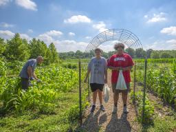 Ted Hibbeler (from left) and brothers Gabe and Mateo Perales work in the Indigenous Garden on East Campus. The garden, which was added this year, is part of the university's Indigenous Food Sovereignty Program.  Kateri Hartman | University Communication 