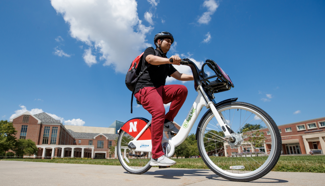 A student rides a Bike LNK bicycle through Meiers Common on the University of Nebraska-Lincoln campus..