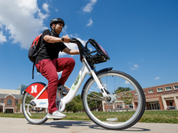 A student rides a Bike LNK bicycle through Meiers Common on the University of Nebraska-Lincoln campus..