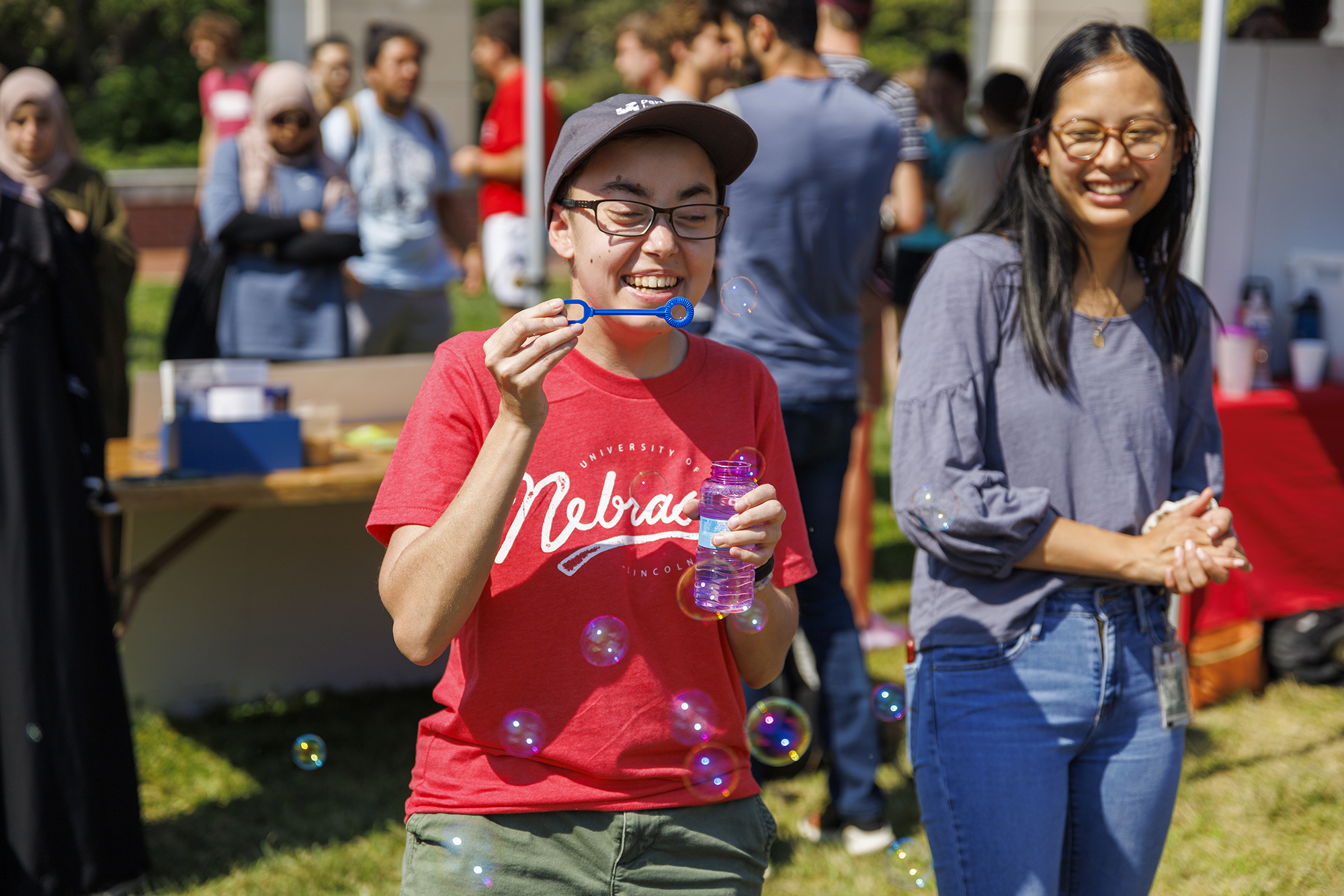 Sarah Roscoe blows bubbles at the UNL Christian Graduate Student table during the Club Fair. August 24, 2022. [Mike Jackson | Student Affairs]