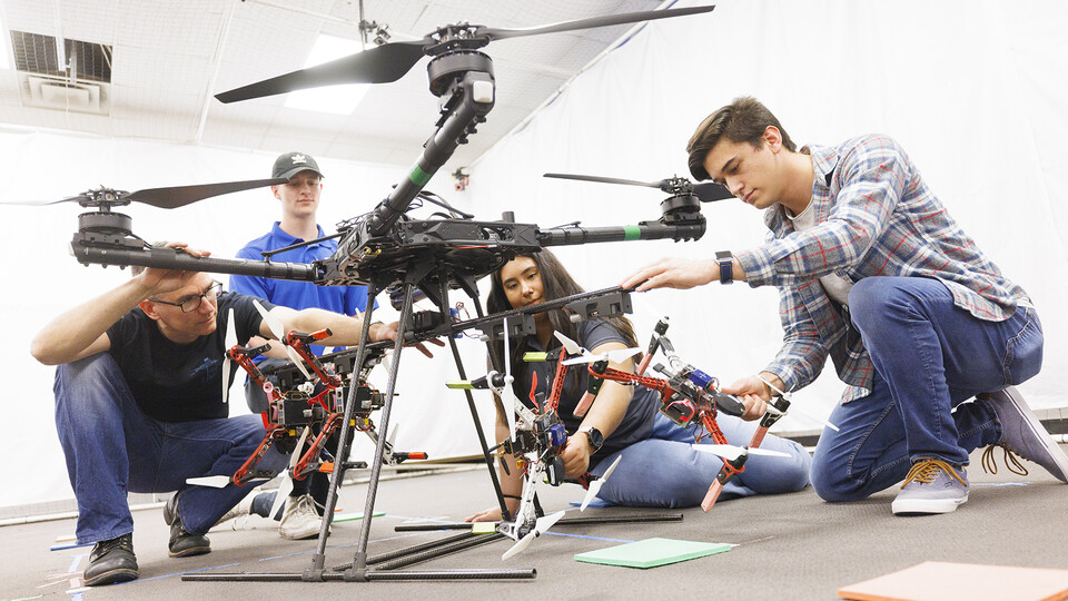Huskers (including STEM CONNECT students Clara Perez and Brandon Ramos at left) work on a drone swarm idea in a College of Engineering lab. The federal award will expand all levels of robotics instruction on campus. Craig Chandler | UComm
