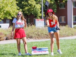 Tenley Simmons, a sophomore from Minneapolis, Minnesota, right, and Kate Aleknavicius, a sophomore from Milkwaukee, Wisconsin, compete in Corn Hole at the Student Tailgate and Unity Walk in the Union green space before the game. NU vs. North Dakota.
