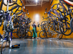 Katie Furlong, a senior from Dallas, adds a bike to the finished side of the repair area in the Outdoor Adventures Center Bike Shop.