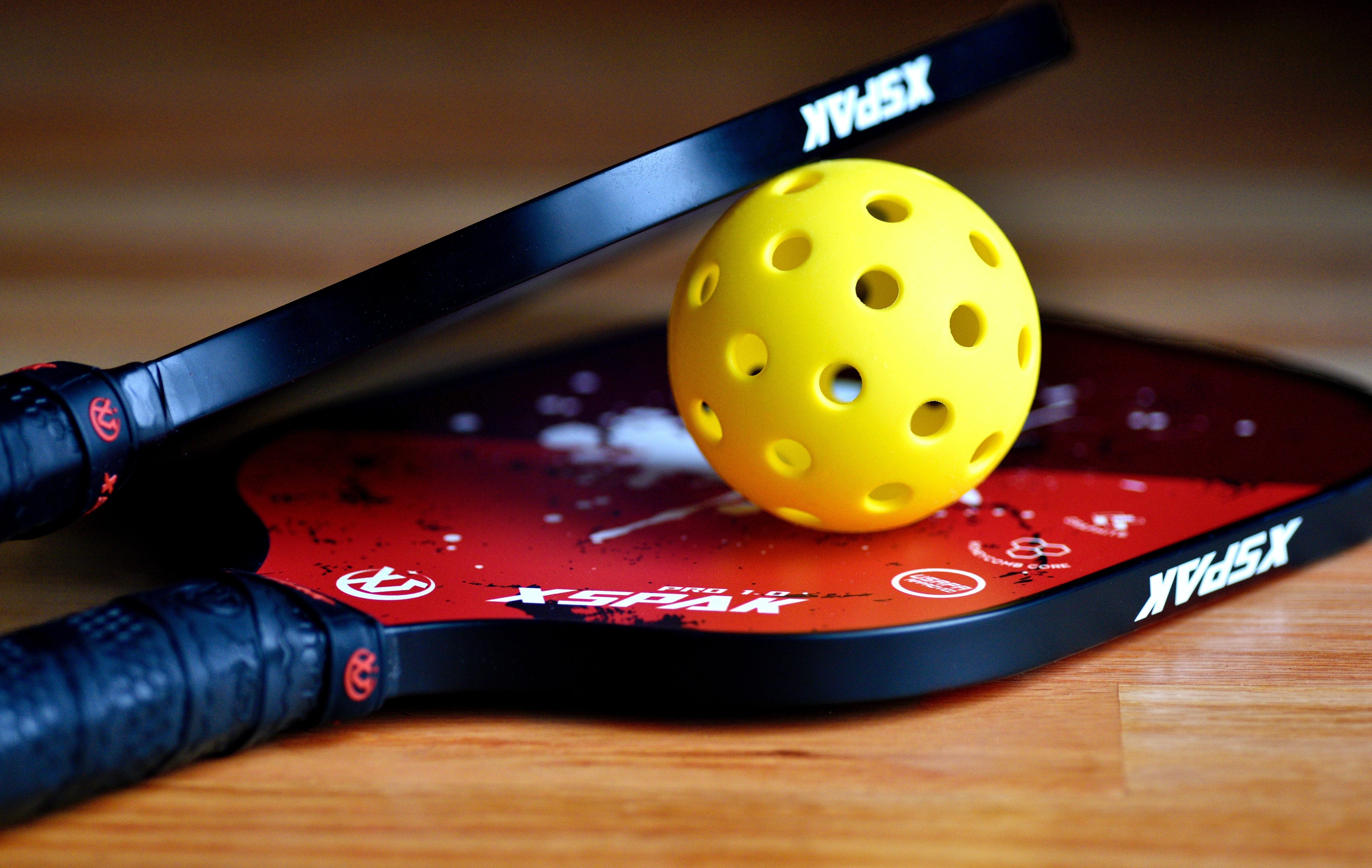 Pickleball paddles and ball. [Photo by Ben Hershey on Unsplash]