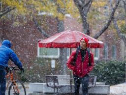 Snow falls as a student walks through the Nebraska's Union's Memorial Plaza. [University Communication]
