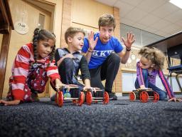 Spencer Knight gets three students and their rubber-band powered cars lined up for a race at Riley Elementary School in Lincoln. [Craig Chandler | University Communication]
