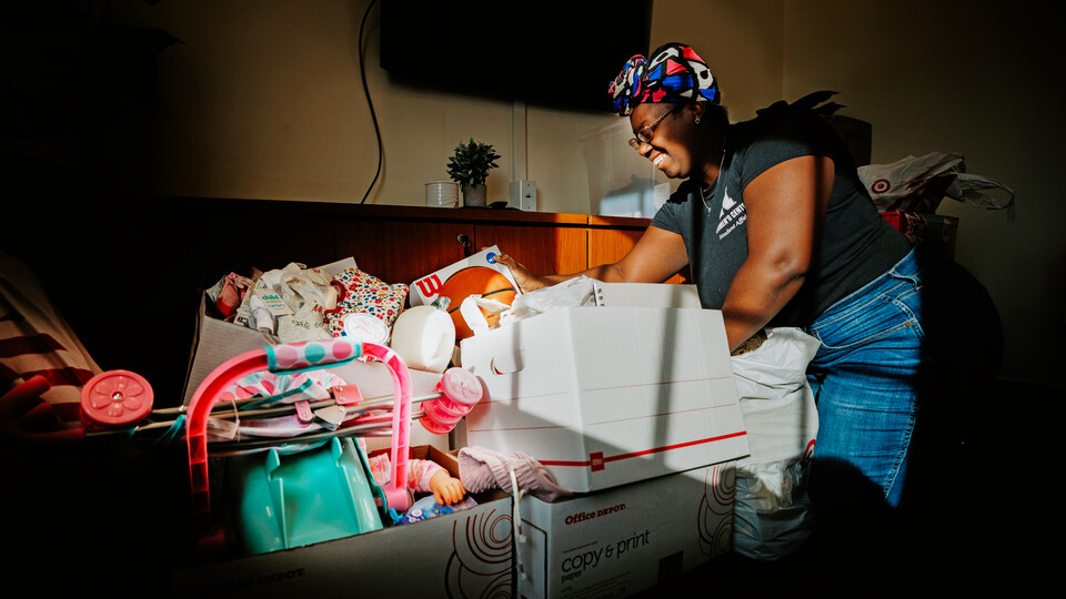  Domonique Cudjo, assistant director, Women’s Center, sorts Holiday for Little Huskers gifts in the center’s conference room.